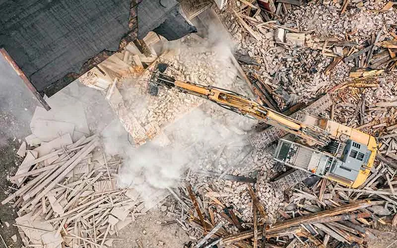 Canteiro de obras com poeira em suspensão durante demolição